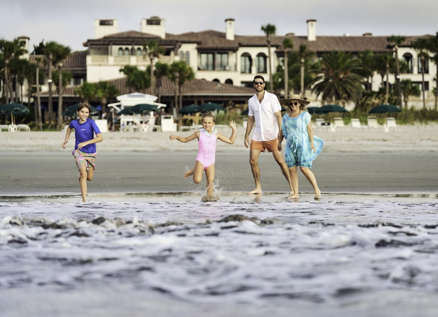 Family running along the beach