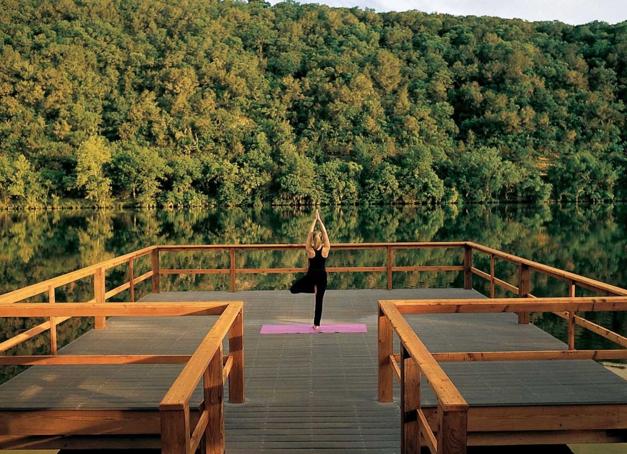 Woman doing yoga at the end of a dock